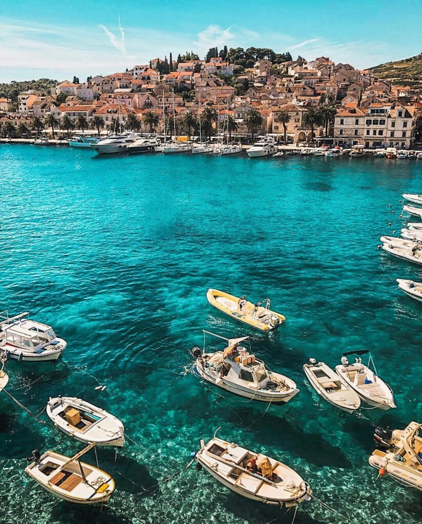 pexels-photo-2265876-2265876 Boats in the vibrant blue waters of Hvar, Croatia, showcasing a charming coastal town under sunny skies.